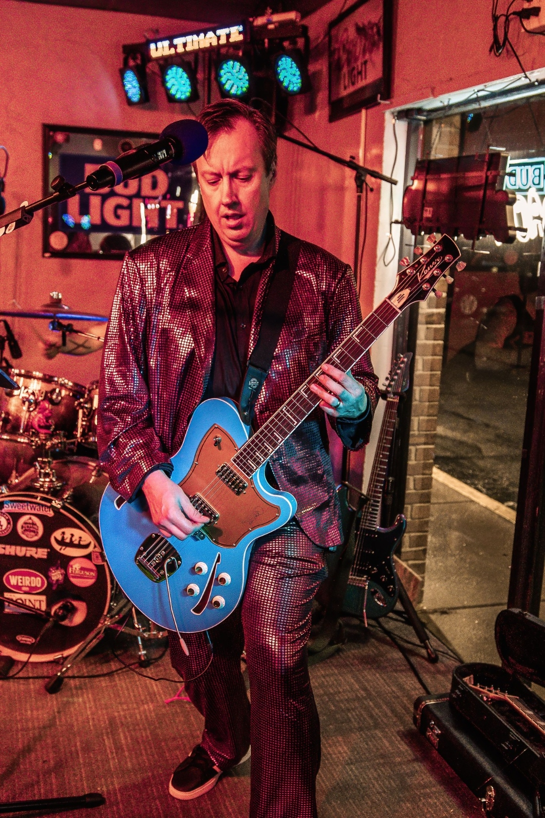 B.U.R.P. guitarist performing live in sequin jacket with blue guitar